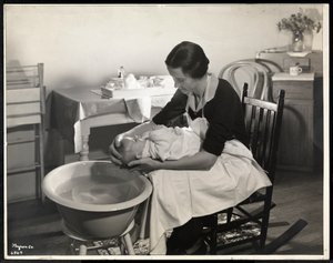 En kvinde vasker en babys hoved hos Maternity Center Association på 211 East 57th Street, New York, 1934 (sølv gelatinetryk)